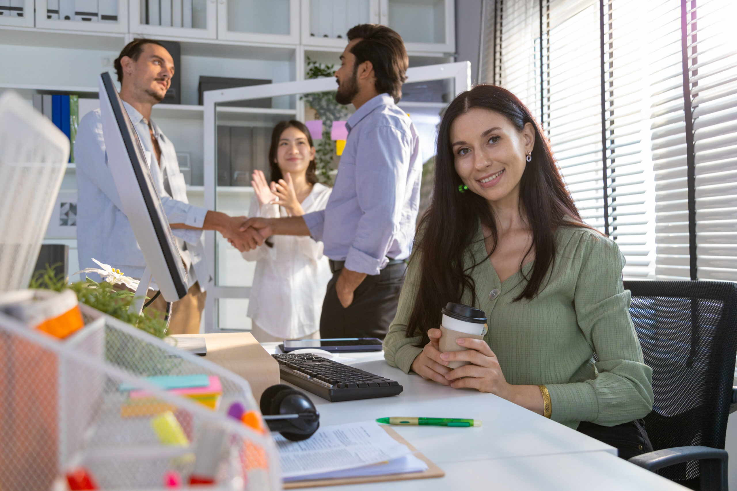 Illustration representing employee retention showing a diverse group of happy employees working together in an office environment.